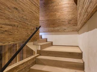 This stunning interior showcases a beautifully crafted wooden staircase, complemented by matching wooden walls and ceiling.