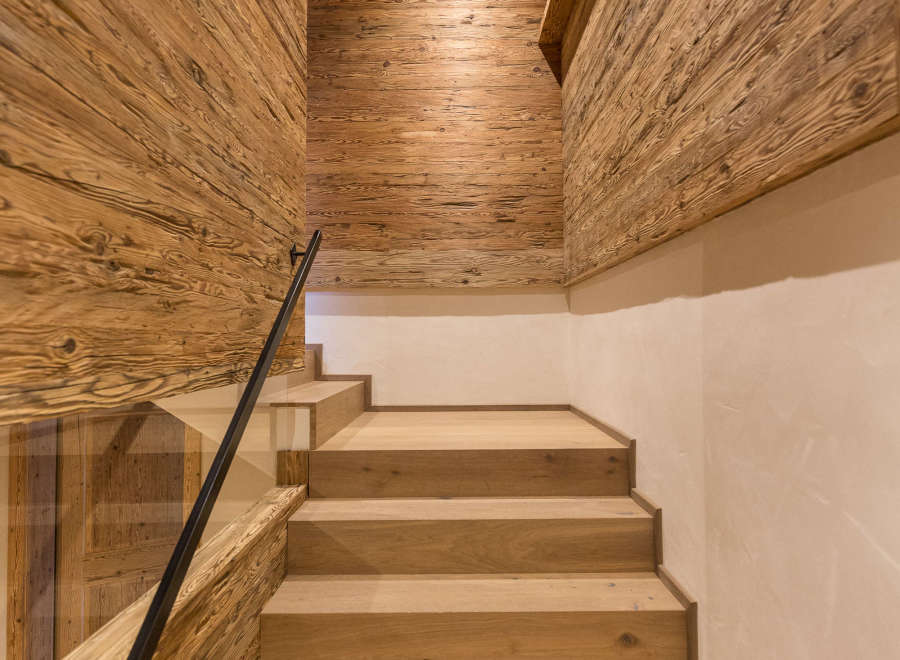This stunning interior showcases a beautifully crafted wooden staircase, complemented by matching wooden walls and ceiling.