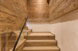 This stunning interior showcases a beautifully crafted wooden staircase, complemented by matching wooden walls and ceiling.