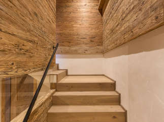 This stunning interior showcases a beautifully crafted wooden staircase, complemented by matching wooden walls and ceiling.