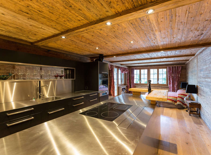 This stunning kitchen boasts a rustic charm with its wooden ceiling and walls, creating a warm and inviting atmosphere.
