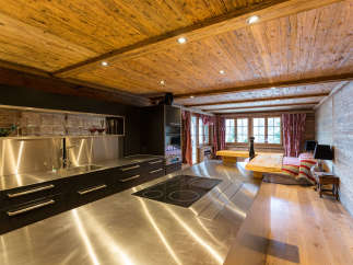 This stunning kitchen boasts a rustic charm with its wooden ceiling and walls, creating a warm and inviting atmosphere.