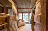 Step into a cozy bedroom retreat featuring rustic wooden bunk beds and a charming seating area.