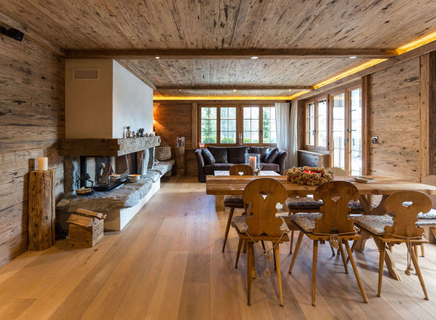 Experience the warmth of this stunning wooden chalet, featuring a cozy fireplace and inviting dining area.