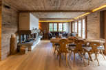 Experience the warmth of this stunning wooden chalet, featuring a cozy fireplace and inviting dining area.