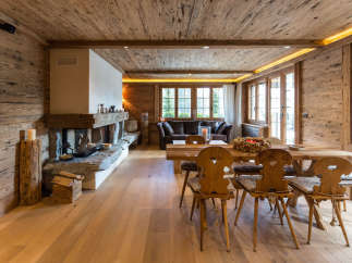 Experience the warmth of this stunning wooden chalet, featuring a cozy fireplace and inviting dining area.