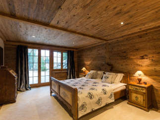 Experience the warmth of this cozy bedroom, featuring stunning wood paneling on the walls and ceiling.