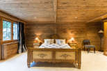 Step into a cozy bedroom retreat with rustic wooden walls and ceiling.
