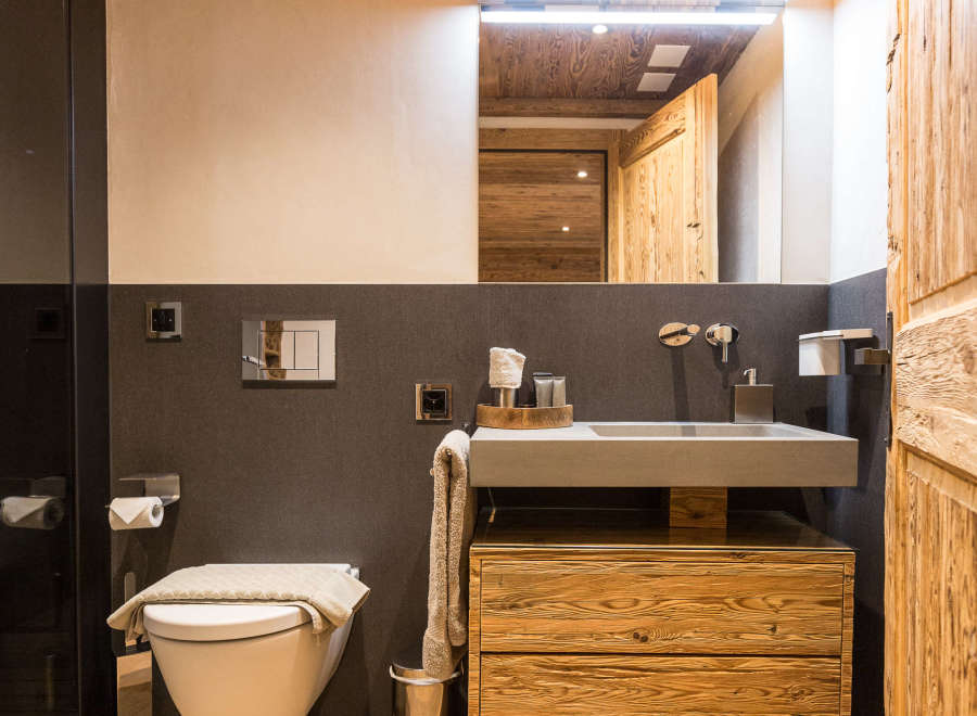 This stunning bathroom boasts a rustic charm with its wooden ceiling and cabinetry.