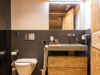 This stunning bathroom boasts a rustic charm with its wooden ceiling and cabinetry.