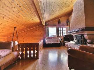This stunning property boasts a cozy interior with a wooden ceiling and walls, creating a warm and inviting atmosphere.