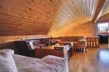 This cozy living space features a stunning wooden ceiling and warm wooden floors, creating a rustic and inviting atmosphere.