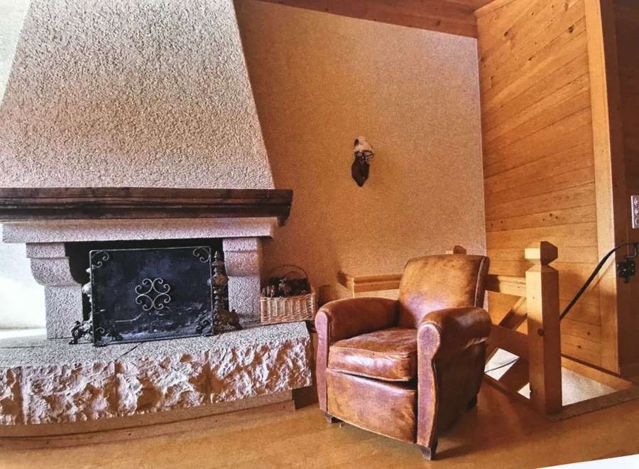 Cozy up in this charming living space featuring a rustic stone fireplace, perfect for those chilly evenings.