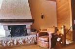 Cozy up in this charming living space featuring a rustic stone fireplace, perfect for those chilly evenings.
