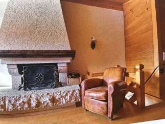 Cozy up in this charming living space featuring a rustic stone fireplace, perfect for those chilly evenings.