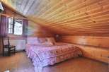 Cozy bedroom with a unique wooden sloped ceiling.