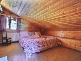 Cozy bedroom with a unique wooden sloped ceiling.