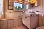 This bathroom features a stunning view of the surrounding nature through a large window.