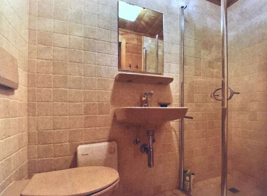 This bathroom features a unique design with tiled walls and a vintage aesthetic.