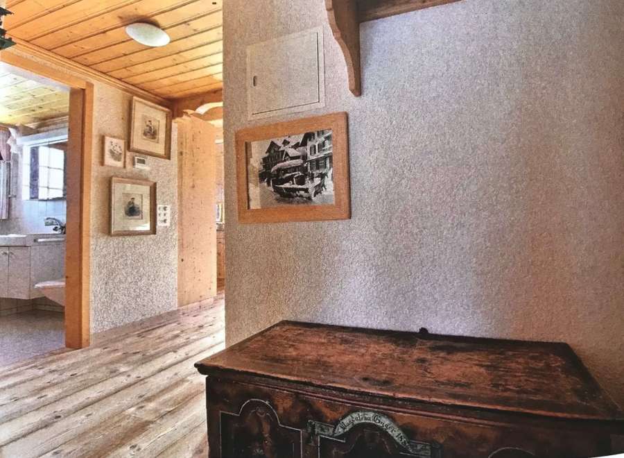 Step into a charming home with a rustic wooden floor and ceiling, creating a warm and inviting atmosphere.