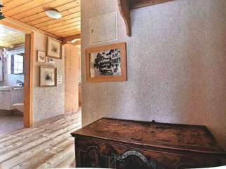 Step into a charming home with a rustic wooden floor and ceiling, creating a warm and inviting atmosphere.