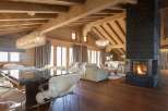 Experience luxury living in this stunning chalet, featuring a cozy fireplace and elegant chandeliers.