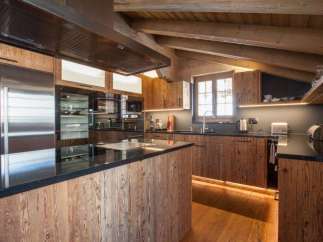 This stunning kitchen boasts a rustic charm with its wooden cabinetry and island, creating a warm and inviting atmosphere.