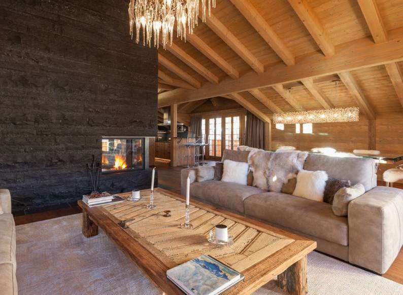 Experience luxury living in this stunning chalet, featuring a cozy fireplace and a beautifully designed wooden ceiling.