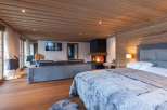 Experience luxury in this stunning bedroom featuring a cozy fireplace and a plush, inviting bed.
