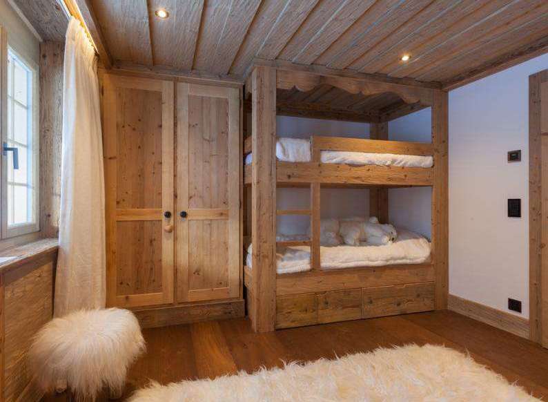 Cozy bedroom featuring a custom-built wooden bunk bed and a spacious wardrobe.