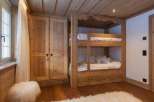 Cozy bedroom featuring a custom-built wooden bunk bed and a spacious wardrobe.