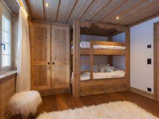 Cozy bedroom featuring a custom-built wooden bunk bed and a spacious wardrobe.