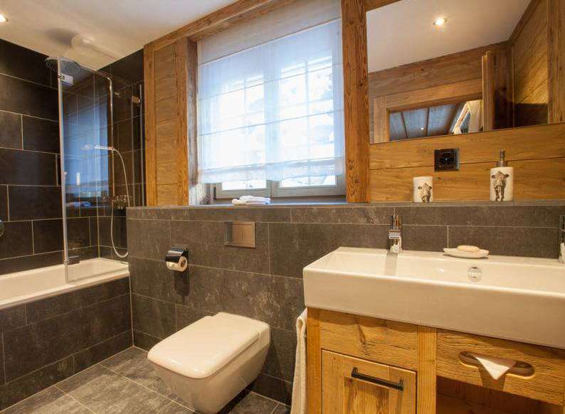This cozy bathroom features a modern design with a touch of rustic charm.