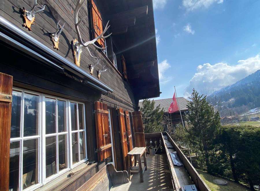 Discover the charm of this traditional wooden chalet, featuring rustic shutters and a welcoming bench.
