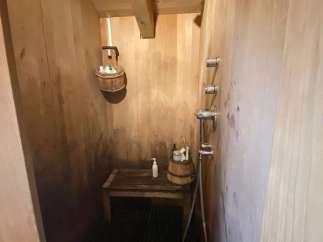 Step into a rustic oasis with this unique wooden shower.