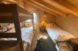 Cozy bedroom with bunk beds and a single bed, perfect for a family getaway.