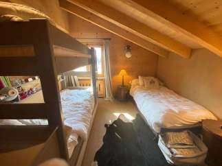 Cozy bedroom with bunk beds and a single bed, perfect for a family getaway.