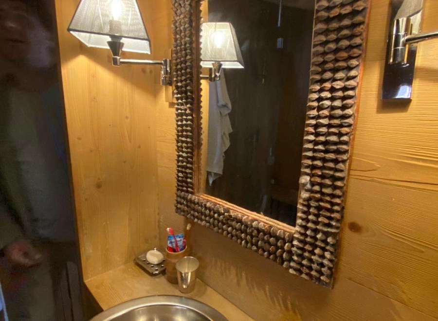 This charming bathroom features a unique mirror frame, adding a touch of rustic elegance.