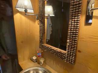 This charming bathroom features a unique mirror frame, adding a touch of rustic elegance.