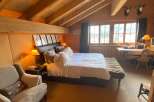 Experience rustic charm in this cozy bedroom, featuring a warm wooden interior and a comfortable bed.