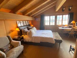 Experience rustic charm in this cozy bedroom, featuring a warm wooden interior and a comfortable bed.