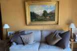 This cozy living space features a comfortable sofa adorned with plush pillows, creating an inviting atmosphere.