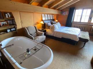 Indulge in luxury in this stunning bedroom featuring a freestanding bathtub, perfect for a relaxing soak.