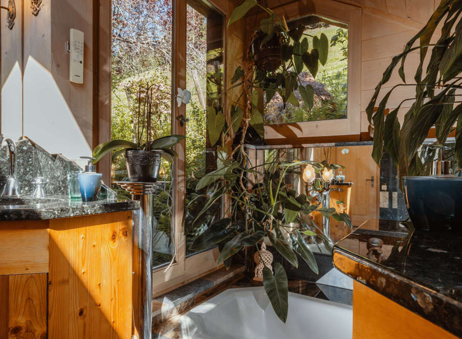 Experience the tranquility of this stunning bathroom, featuring a luxurious bathtub and a serene view of the outdoors.
