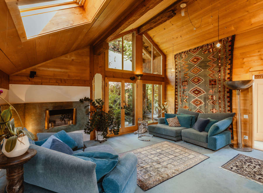 Step into a cozy living space with a stunning wooden ceiling and natural light pouring in from the skylight.