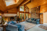 Step into a cozy living space with a stunning wooden ceiling and natural light pouring in from the skylight.