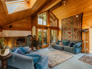 Step into a cozy living space with a stunning wooden ceiling and natural light pouring in from the skylight.
