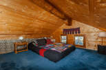 Cozy bedroom in a wooden cabin with a unique, colorful quilt.
