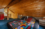 Cozy cabin bedroom with a unique, colorful quilt.