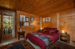 Cozy bedroom with wooden walls and ceiling, creating a warm and inviting atmosphere.